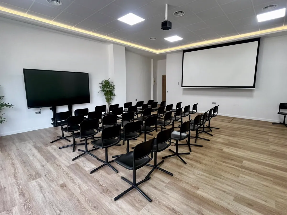 The Felgueroso Room with its digital whiteboard, projection screen and chairs in rows